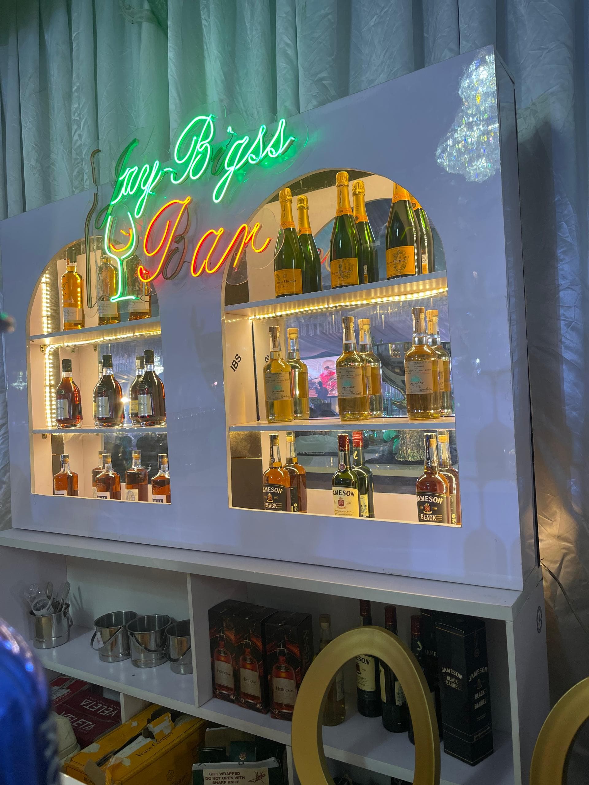 Mixologist pouring an amber cocktail at a black marble event bar